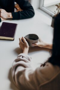 woman holding gray mug at table